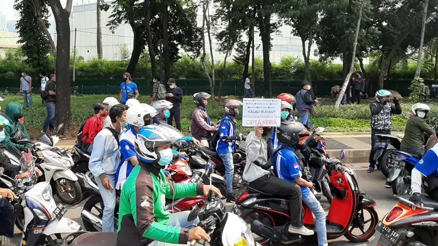 Rombongan buruh yang demo melintas di Jalan Gatot Subroto, Jakarta.