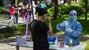 Seorang petugas kesehatan bersiap untuk melakukan tes swab COVID-19 di kompleks perumahan saat lockdown tahap kedua di Distrik Jing'an, Shanghai, China, Rabu (6/4/2022). (HECTOR RETAMAL/AFP)