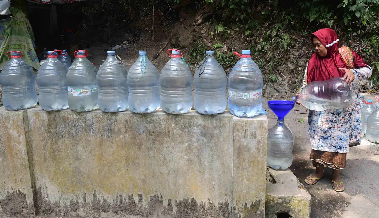 Warga  mengambil air untuk minum dan kebutuhan mck rumah  di sumber mata air Sumur Bendung, Gunung Batur, Kota Cilegon, Banten, Minggu, (15/7/2026). (KLY/Arie Basuki)