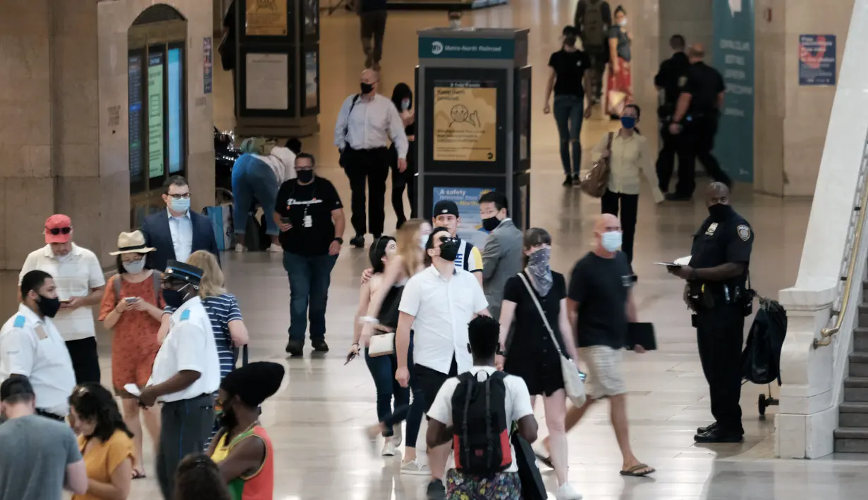 Orang-orang dengan masker berjalan di Grand Central Terminal, New York City, Selasa (27/7/2021). Warga Amerika yang divaksinasi penuh harus kembali memakai masker di dalam ruangan di daerah-daerah di mana virus corona dan terutama varian Delta menyebar dengan cepat. (Spencer Platt/Getty Images/AFP)