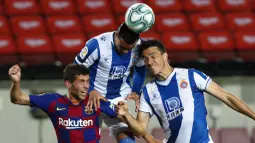 Pemain Barcelona, Sergi Roberto, duel udara dengan pemain Espanyol, Raul De Tomas dan Bernardo Espinosa, pada laga La Liga di Stadion Camp Nou, Rabu (8/7/2020). Barcelona menang 1-0 atas Espanyol. (AP/Joan Monfort)