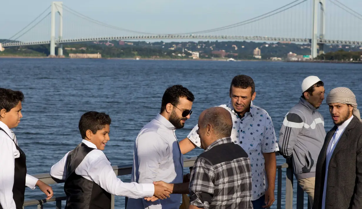 Warga saling bersalaman saat mereka bersiap melaksanakan salat Idul Adha di Taman Bensonhurst di wilayah Brooklyn di New York (1/9). Umat Muslim di seluruh dunia merayakan Hari RayaIdul Adha. (AP Photo / Mark Lennihan)