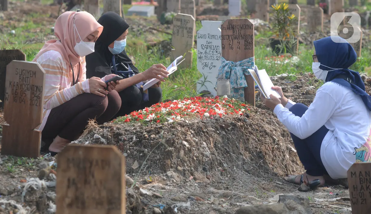 Warga berdoa di depan pusara keluarganya saat ziarah kubur di TPU Srengseng Sawah 2, Jagakarsa, Jakarta Selatan, Senin (17/5/2021). Hari ini seluruh TPU di wilayah DKI dibuka untuk umum dengan menerapkan protokol kesehatan seperti pembatasan pengunjung dan waktu berziarah. (merdeka.com/Arie Basuki)