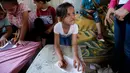 Gadis Palestina, Fajr Hmaid (tidak dalam foto) mengajar anak-anak dari lingkungannya dalam kelas darurat di Kota Gaza, Kamis (4/6/2020). Gadis berusia 13 tahun itu membantu mereka untuk mengejar pelajaran setelah sekolah ditutup oleh pemerintah setempat akibat pandemi Covid-19. (Mohammed ABED / AFP)