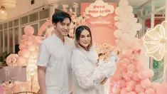 Dalam momen akikah sang anak, Kevin Aprilio dan Vicy Melanie tampil selaras dengan busana warna putih. Kevin gagah dengan baju koko, sementara Vicy Melanie anggun dengan dress dan memakai hijab yang menutupi sebagian rambutnya. Lahir pada 5 Oktober 2024, Baby Kimova di akikah ketika usianya 1,5 bulan. Dikaruniai anak pertama setelah 4 tahun, kebahagiaan terpancar jelas di wajah pasangan ini. (Liputan6.com/IG/@vicymelanie)