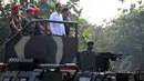 Presiden Joko Widodo saat menaiki Panser Anoa ditemani panglima TNI Jenderal Moeldoko dan Para Kepala Kesatuan jelang upacara pengangkatan dirinya sebagai warga kehormatan pasukan khusus TNI, Kamis (16/4/2015). (Liputan6.com/Yoppy Renato)
