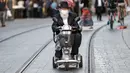 Seorang pria Yahudi Ultra-Ortodoks tua, yang mengenakan masker karena pandemi virus corona COVID-19, mengendarai skuter mobilitas roda tiga di sepanjang jalan di Yerusalem (26/10/2020). (AFP/Emmanuel Dunand)