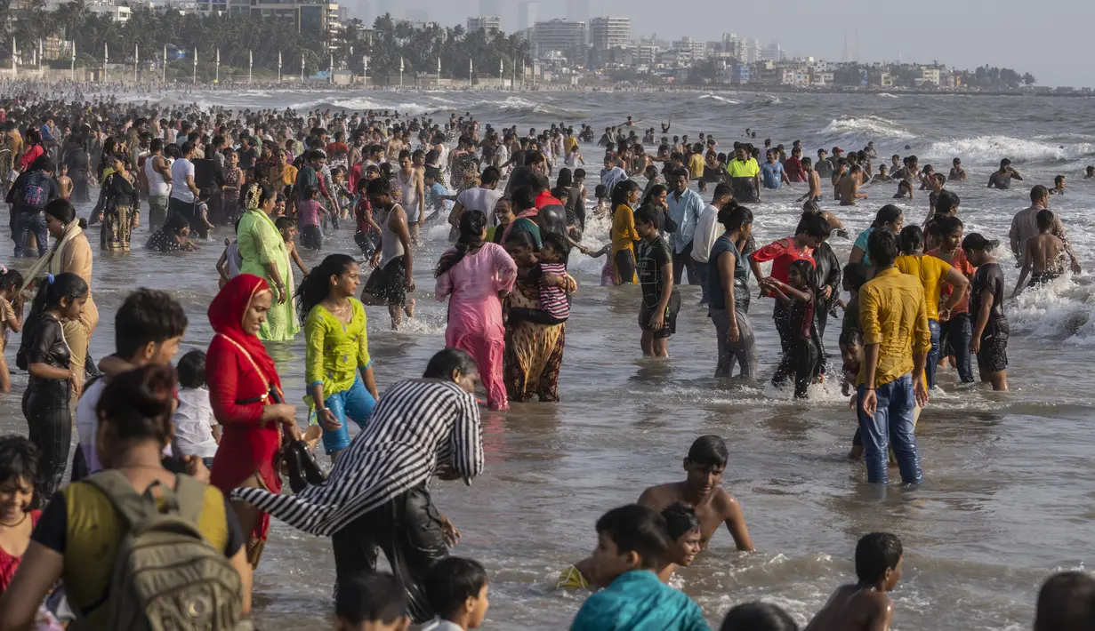 <p>Pengunjung memadati pantai Juhu di Laut Arab pada hari yang panas dan lembab di kota Mumbai, India, 8 Mei 2022. Tingginya suhu udara diperparah dengan kurangnya curah hujan. Maret lalu tercatat sebagai bulan terpanas di India sejak 122 tahun lalu. (AP Photo/Rafiq Maqbool)</p>