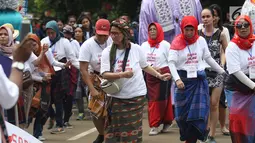 Pengunjung menari saat Festival Sarung Indonesia 2019 di Kawasan Kompleks Gelora Bung Karno, Jakarta, Minggu (3/3). Festival ini untuk menghidupkan kesadaran dan kebanggaan generasi muda akan kekayaan budaya Indonesia. (Liputan6.com/Helmi Fithriansyah)