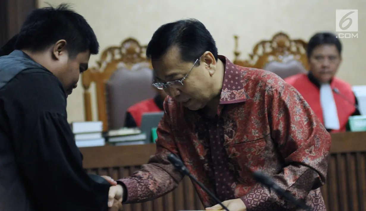 Terdakwa korupsi proyek e-KTP, Setya Novanto menyalami JPU usai membagikan buku pada sidang pembacaan nota pembelaan di Pengadilan Tipikor, Jakarta, Jumat (13/4). Sidang mendengar pembacaan nota pembelaan terdakwa. (Liputan6.com/Helmi Fithriansyah)