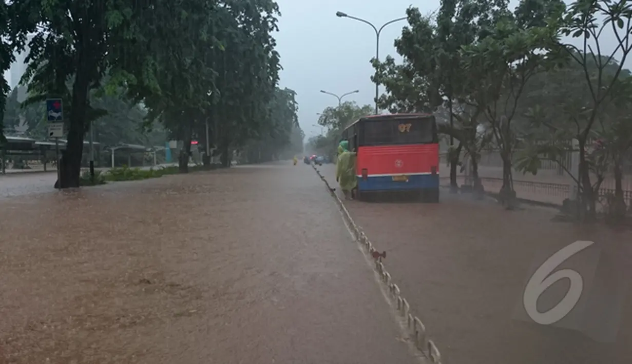 Sebuah angkutan umum mogok akibat nekat menerobos banjir yang menggenangi jalan Letjen Suprapto Cempaka Putih, Jakarta, Senin (9/2/2015). (Liputan6.com/Herman Zakharia)
