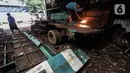 Seorang pekerja membelah Koperasi Angkutan Jakarta (Kopaja) yang akan diremajakan di kawasan Meruya, Jakarta Barat, Rabu (27/1/2021). Kopaja yang tak lagi digunakan tersebut dihancurkan untuk dijual secara kiloan ke penjual besi tua. (Liputan6.com/Johan Tallo)
