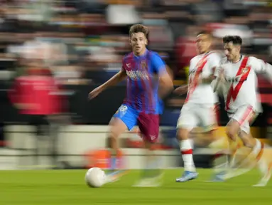 Foto yang diambil dengan kecepatan rana lambat ini menunjukkan pemain Barcelona Nico Gonzalez berlari dengan bola saat melawan Rayo Vallecano pada pertandingan La Liga Spanyol di Stadion Vallecas, Madrid, Spanyol, 27 Oktober 2021. Barcelona kalah 0-1. (AP Photo/Manu Fernandez)