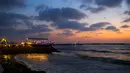 Pemandangan di sekitar restoran berbentuk perahu di tepi pantai Kota Gaza, Jalur Gaza, Palestina, Rabu (2/8). Restoran yang berada di atas batu karang tersebut menyuguhkan indahnya langit dengan gradasi warna biru dan oranye. (MOHAMMED ABED / AFP)