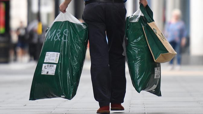 Seorang pelanggan meninggalkan toko Marks and Spencer di pusat kota London, Selasa (18/8/2020). Peretail Inggris, Marks & Spencer pada Selasa (18/8) mengumumkan rencananya untuk memangkas 7.000 pekerja dalam tiga bulan ke depan di tengah pandemi COVID-19. (Photo by JUSTIN TALLIS / AFP)