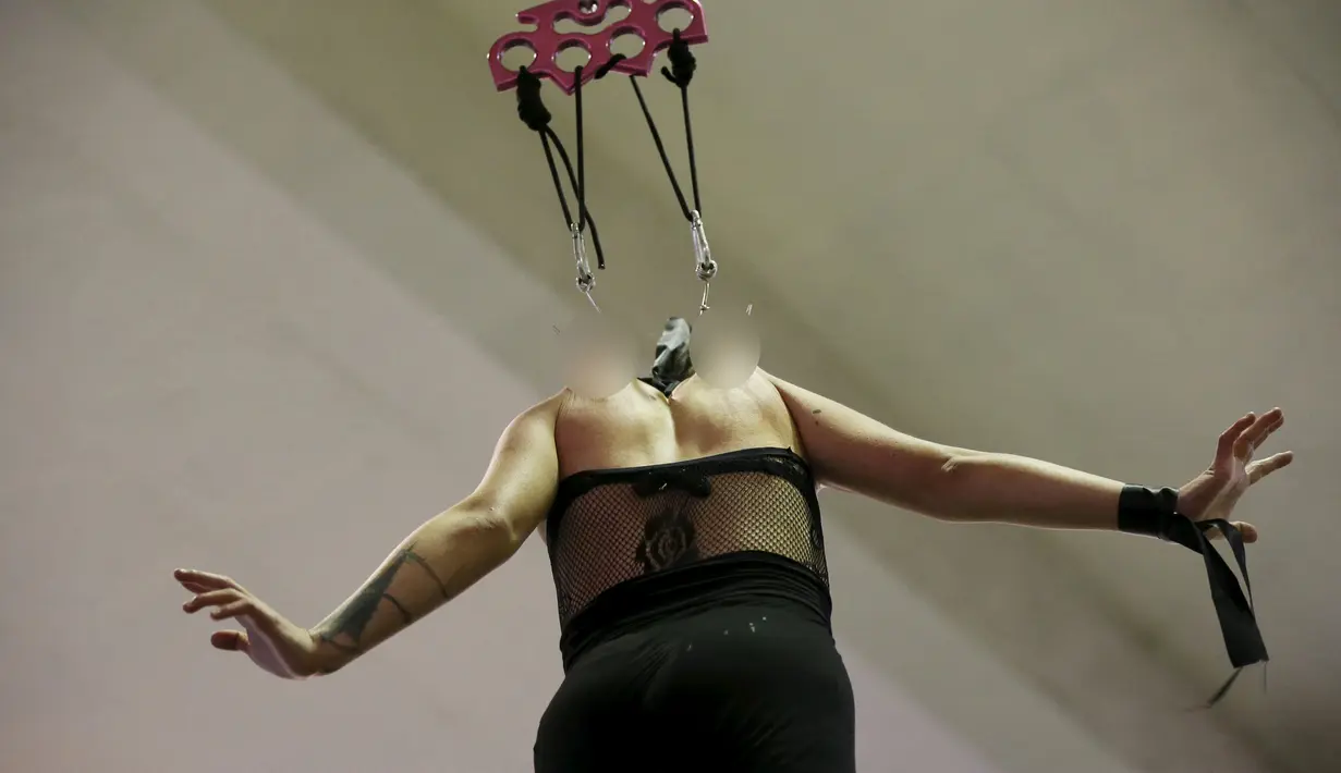 Wanita dikaitkan sebuah besi dan diangkat ke udara selama acara Tattoo and Suspension Convention di Valparaiso, Chili, (8/11/2015). Acara ini merupakan kegiatan untuk para penyuka tato dan modifikasi tubuh di Chili.  (REUTERS/Rodrigo Garrido)