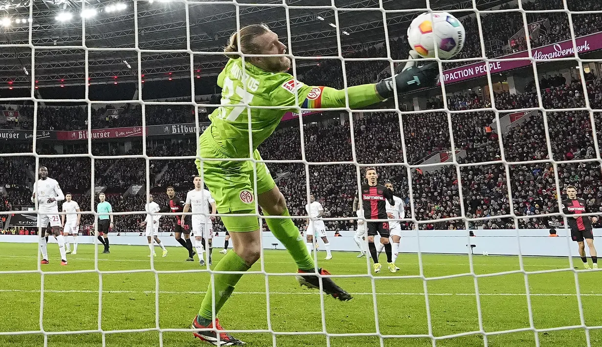 Kiper Mainz, Robin Zentner, gagal menghalau bola saat melawan Bayer Leverkusen dalam duel pekan ke-23 Bundesliga di Stadion BayArena, Sabtu (24/2/2024). (AP Photo/Martin Meissner)