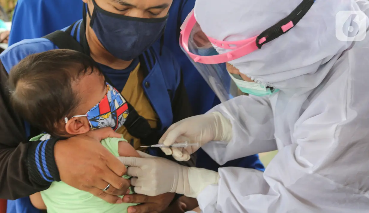 Bidan lengkap dengan baju APD memberi imunisasi pada anak di Posko Imunisasi, Kelurahan Bakti Jaya, Tangerang Selatan, Senin (11/5/2020). Bila melewatkan imunisasi, anak dikhawatirkan rentan tertular penyakit dan mengalami sakit berat saat pandemi Covid-19. (Liputan6.com/Fery Pradolo)