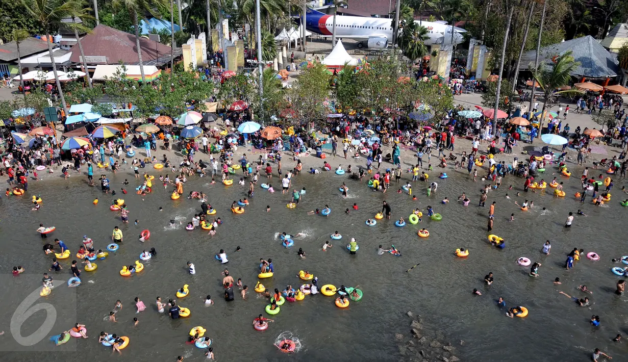 Ribuan pengunjung menikmati liburan di pantai Ancol, Jakarta, Sabtu (18/7/2015). Wisata pantai Ancol masih menjadi pilihan favorit warga Jakarta untuk mengisi libur lebaran kedua ini bersama keluarga. (Liputan6.com/JohanTallo)