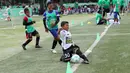 Layaknya pemain profesional, seorang anak berusaha menghalau bola yang keluar lapangan saat mengikuti Milo Football Clinic di Lapangan Sepak Bola Pertamina, Simprug, Jakarta, Minggu (24/4/2016). (Bola.com/Nicklas Hanoatubun)