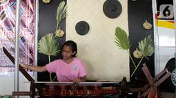 Seorang anak menenun pada acara Sunda Kecil Expo dalam Festival Menipo di Kupang, NTT, Kamis (14/11/2019). Festival Menipo ini adalah jawaban terhadap kemampuan untuk menjaga kelestarian lingkungan alam dan ekosistemnya dengan meningkatkan sektor pariwisata di area Menipo. (Liputan6.com/HO/Purew)