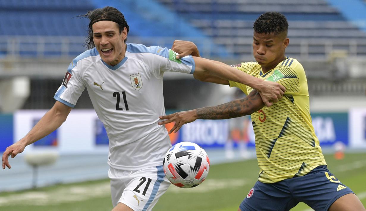 Penyerang Uruguay, Edinson Cavani, berebut bola dengan gelandang Kolombia, Wilmar Barrios, pada laga kualifikasi Piala Dunia 2022 zona CONMEBOL di Estadio Metropolitano Roberto Melendez, Sabut (14/11/2020) dini hari WIB. Uruguay menang 3-0 atas Kolombia. (AFP/Raul Arboleda)