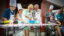 Pangeran Charles bersama sang istri Camilla Parker membuat kue lamington bersama anak-anak di Brisbane, Australia, Rabu (4/4). Kegiatan itu dilakukan dalam kunjungannya ke Rumah Sakit Anak Lady Cilento. (Patrick HAMILTON/POOL/AFP)