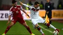 Gelandang Jerman, Mesut Ozil (kanan) mengontrol bola di samping pemain Georgia Giorgi Chanturia saat kualifikasi Piala Eropa 2016 di Locomotiv Stadium, Minggu (29/3/2015). Jerman menang 2-0 atas Georgia. (AFP PHOTO/Patrik Stollarz)