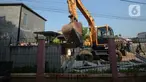 Pekerja menggunakan alat berat saat merobohkan pagar beton yang mengisolasi sejumlah warga di Jalan Akasia, Tajur Ciledug, Tangerang, Banten, Rabu ( 17/3/2021). Pagar beton yang sempat menutup akses jalan warga tersebut kini dibongkar. (merdeka.com/Imam Buhori)