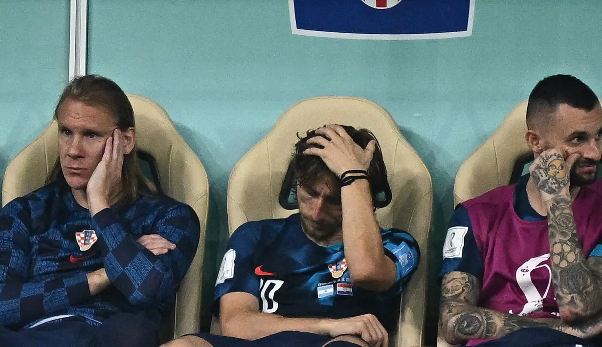 Gelandang Kroasia #10 Luka Modric (Tengah) bereaksi setelah timnya kalah dari Argentina pada babak semifinal Piala Dunia 2022 di Stadion Lusail, Rabu (14/12/2022) dini hari WIB. Meskipun tersingkir, Luka Modric dkk. akan menghadapi tim yang kalah dalam duel Prancis Vs Maroko pada perebutan tempat ketiga. (Anne-Christine POUJOULAT / AFP)