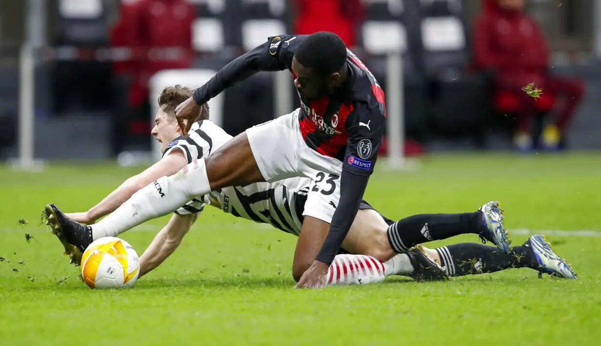 Pemain Manchester United Daniel James (belakang) memperebutkan bola dengan pemain AC Milan Fikayo Tomori pada pertandingan leg kedua babak 16 besar Liga Europa di Stadion San Siro, Milan, Italia, Kamis (18/3/2021). Manchester United  menang 1-0. (AP Photo/Antonio Calanni)