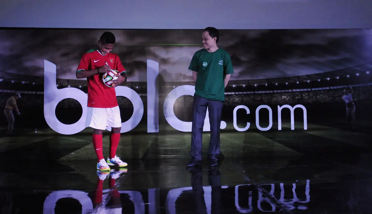 Pemain timnas Indonesia, Ramdani Lestaluhu (kiri) bersama CEO KMK Adi Sariaatmadja menandatangi bola saat peluncuran portal berita olahraga online Bola.com di Jakarta, Selasa (28/4/2015). (Liputan6.com/Helmi Fithriansyah)