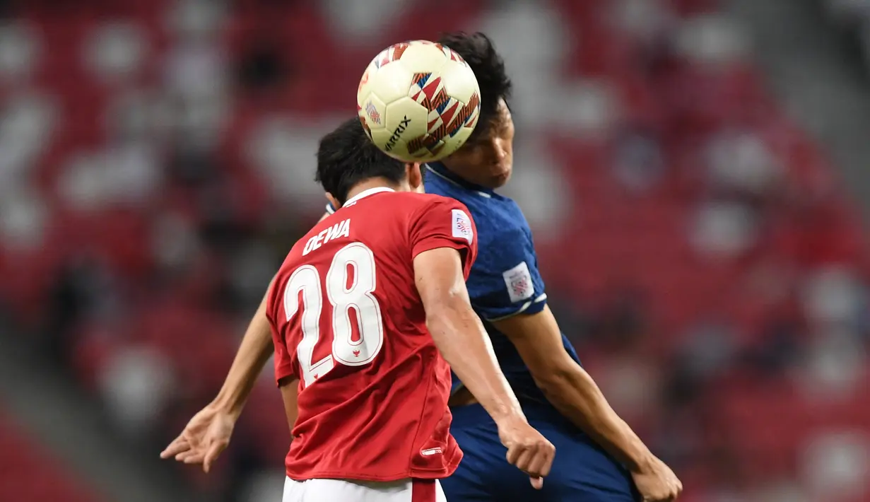 Bek Timnas Indonesia Dewangga Santosa (kiri) berebut bola dengan striker Timnas Thailand Supachai Chaidedd dalam pertandingan Babak Final Leg 1 Piala AFF 2020 di National Stadium, Singapura, Rabu (29/12/2021). Laga antara Indonesia vs Thailand berakhir dengan skor 0-4. (Roslan RAHMAN/AFP)