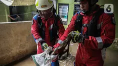 Petugas dari Dinas Penanggulangan Kebakaran dan Penyelamatan Provinsi DKI Jakarta (Gulkarmat) Jakarta Timur mengevakuasi seekor ular di kawasan Kebon Pala, Kampung Melayu, Jakarta, Jumat, (1/12/2023). (Liputan6.com/Faizal Fanani)