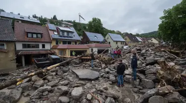 Warga saat memeriksa lokasi tempat tinggal mereka pasca luapan banjir di wilayah Braunsbach, Jerman selatan (30/5). Banjir membawa beragam material lumpur bercampur batu serta ranting hingga batang pohon. (Marijan Murat / dpa / AFP)