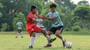 Pemain Timnas Indonesia U-16, Fabio Azka Irawan (kanan) berebut bola dengan seorang pemain SSB terang Bangsa pada laga uji coba di Lapangan Yogyakarta International School (YIS), Jumat (31/5/2024). (Bola.com/Radifa Arsa)