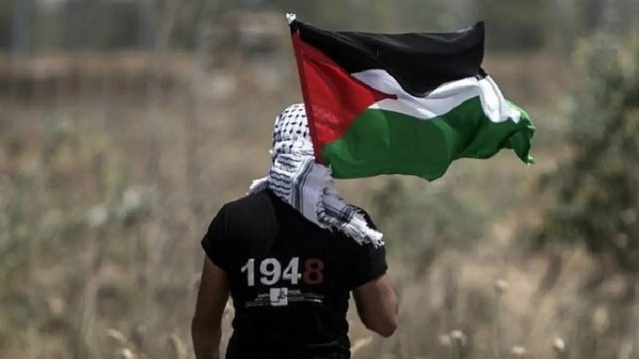 Pemuda Palestina mengibarkan bendera nasional.