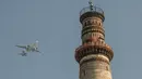 Pesawat terbang melintas dekat situs warisan dunia UNESCO Qutub Minar di New Delhi, India, Kamis (13/2/2020). Bangunan ini pernah diterjang bencana alam berkali-kali, namun tetap kokoh. (Xinhua/Javed Dar)