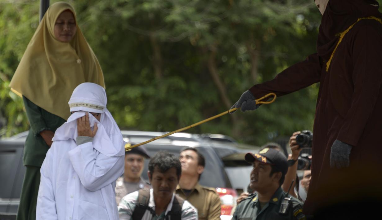 Tjia Nyuk Hwa dicambuk di luar Masjid Babussalam, Banda Aceh, Aceh, Indonesia, Selasa (27/2). Tjia Nyuk Hwa bersama suaminya, Dahlan Silitonga dicambuk karena bermain judi. (AFP FOTO/CHAIDEER MAHYUDDIN)