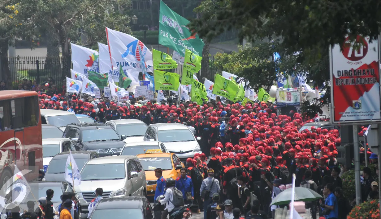 Ribuan buruh berjalan menuju bundaran Istana Merdeka, Jakarta, Jumat (30/10/2015). Aksi tersebut menimbulkan kemacetan lalu lintas kendaraan di sekitar kawasan Istana Negara. (Liputan6.com/Gempur M Surya)