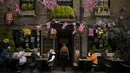 Pelanggan duduk di luar pub yang dihiasi bendera Union Jack dan gambar Raja Charles III, di Windsor, Inggris, Jumat, 5 Mei 2023. Penobatan Raja Charles III akan berlangsung di Westminster Abbey pada 6 Mei. (AP Photo/ Andreea Alexandru)
