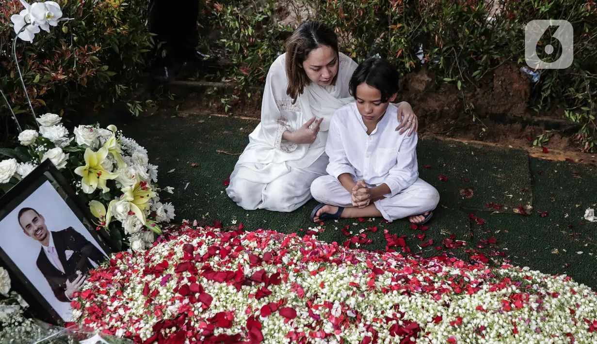 Bunga Citra Lestari atau BCL bersama anaknya Noah Sinclair duduk di samping makam Ashraf Sinclair di San Diego Hills, Karawang, Jawa Barat, Selasa (18/2/2020). Ashraf Sinclair mengembuskan napas terakhir pukul 04.51 WIB pagi tadi. (Liputan6.com/Faizal Fanani)