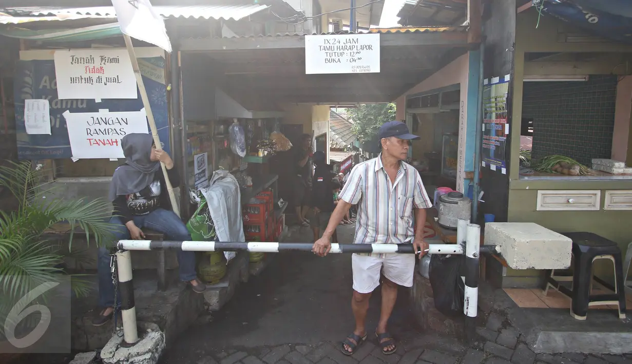 Warga Jalan Lauser, RT 08/08, Kebayoran Baru, Jakarta, menjaga ketat pintu masuk permukiman mereka, Senin (9/5). Penjagaan dilakukan lantaran hari ini diisukan akan ada penyampaian SP-2 terkait penggusuran di lokasi itu. (Liputan6.com/Immanuel Antonius)