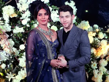Pasangan aktris Bollywood Priyanka Chopra dan musisi Nick Jonas berpose untuk resepsi pernikahan mereka di Mumbai, India, Rabu (19/12). Resepsi kedua Priyanka Chopra dan Nick Jonas hanya mengundang kerabat dan teman dekat. (AP/Rajanish Kakade)