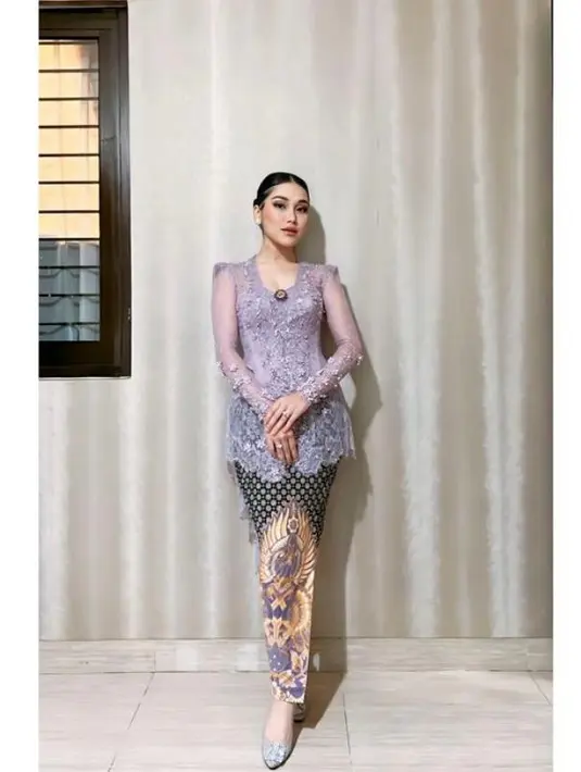 Ayu Ting Ting mengenakan kebaya brokat warna lilac dengan detail ekor panjang, dipadu kain batik. [@ayutingting92].