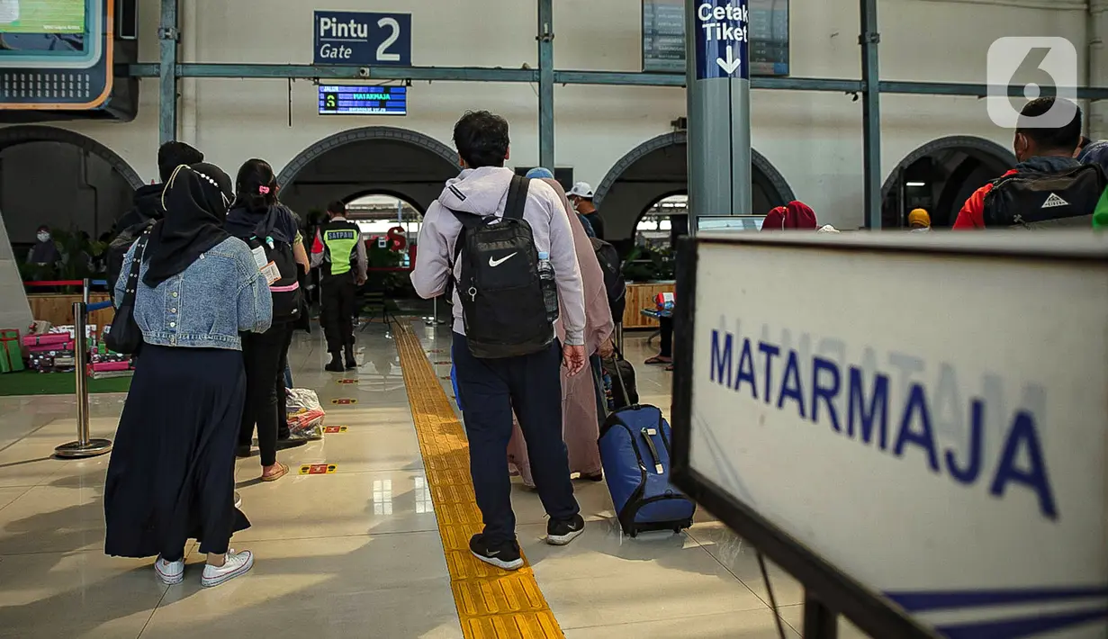 Sejumlah calon penumpang kereta antre memasuki Stasiun Pasar Senen, Jakarta, Jumat (24/12/2021). PT Kereta Api Indonesia (KAI) menambah jumlah kereta jarak jauh selama libur Natal dan Tahun Baru. (Liputan6.com/Faizal Fanani)