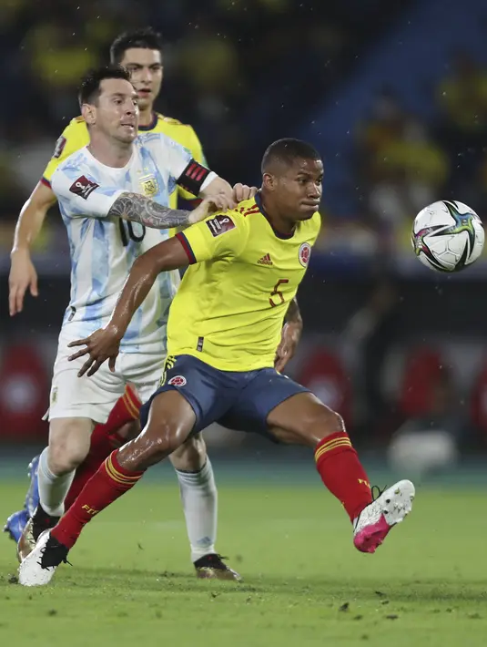 Penyerang timnas Argentina, Lionel Messi mendorong gelandang Kolombia, Wilmar Barrios pada laga lanjutan Kualifikasi Piala Dunia 2022 Zona Amerika Selatan di Stadion Metropolitano, Rabu (9/6/2021) pagi WIB. Argentina harus puas bermain imbang 2-2 dengan Kolombia. (AP Photo/Fernando Vergara)
