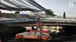 Petugas Dinas Sumber Daya Air DKI Jakarta memasang sling sebelum pemasangan waring di Kali Sentiong atau Kali Item, Tanjung Priok, Selasa (31/7). Pemprov DKI Jakarta menambah pemasangan waring dari Jembatan Marto. (Merdeka.com/Iqbal S Nugroho)