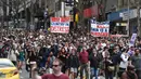 Para pengunjuk rasa berbaris di jalan-jalan selama rapat umum anti-lockdown di tengah penguncian keenam kota untuk menahan wabah virus corona di Melbourne (21/8/2021). (AFP/William West)