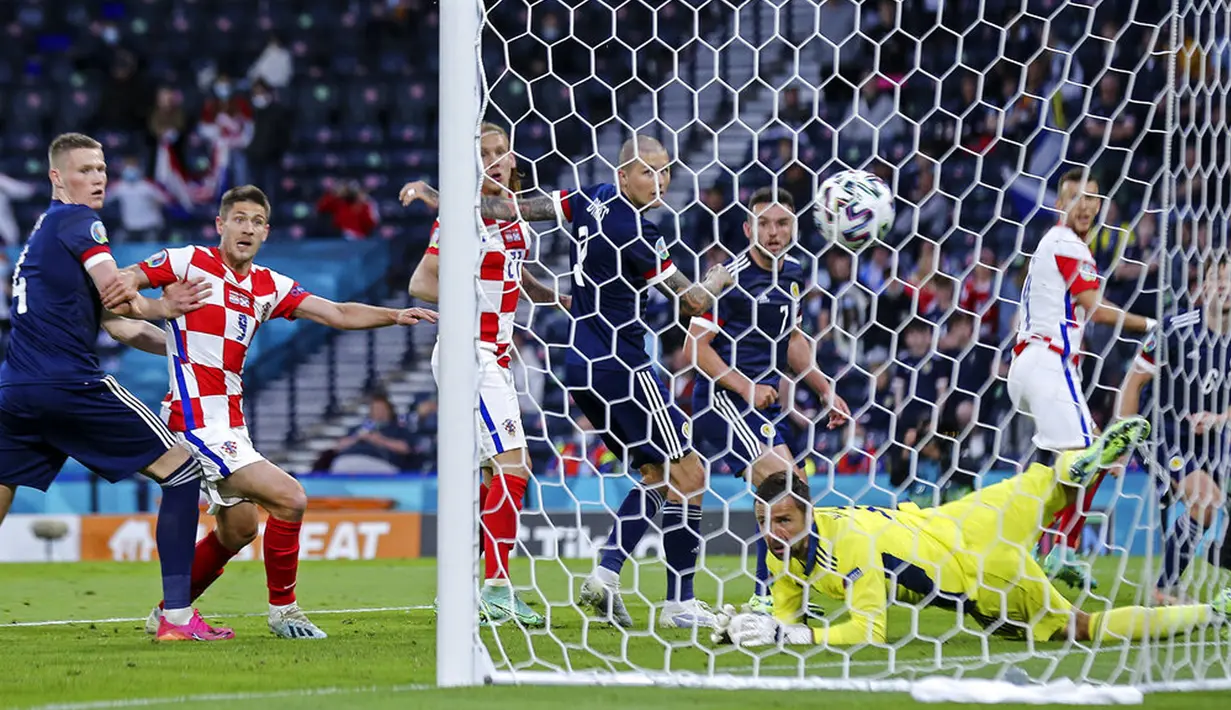 Penjaga gawang Skotlandia David Marshall menerima gol dari pemain Kroasia Ivan Perisic (kanan) pada pertandingan Grup D Euro 2020 di Stadion Hampden Park, Glasgow, Selasa (22/6/2021). Kroasia menang 3-1. (Robert Perry/Pool via AP)